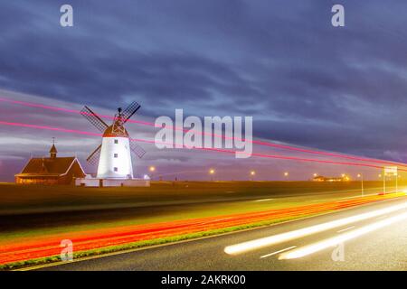 Lytham, Lancashire. UK Wetter. 10 Jan, 2020. gedeckten Farben bei dawnm und verschwommene Lichter vom Verkehr leavig rote Spuren, nach einer kalten Nacht auf die fylde Coast. Lytham Windmühle als sonnenaufgänge auf Lytham Grün in der Küstenstadt Lytham St Annes, Lancashire, England. Es ist von der Art wie ein Tower Mill bekannt und wurde für das Schleifen von Weizen und Hafer Mehl oder Kleie entworfen. Kredit; MediaWorldImages/AlamyLiveNews Stockfoto