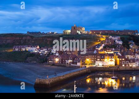 Whitby, mit Blick über den Hafen in Richtung der Marienkirche und den Ruinen der Abbey in der Dämmerung. Stockfoto