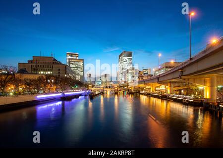 Osaka Hochhaus Gebäude mit Tosahori Fluss in Nakanoshima business district in der Nacht in Osaka, Japan. Japan Tourismus, moderne Stadt leben, oder Business Stockfoto