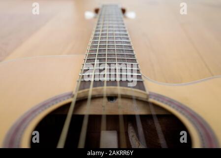 Gitarrendetail mit Körper und Hals, auf Holzboden verlegt Stockfoto