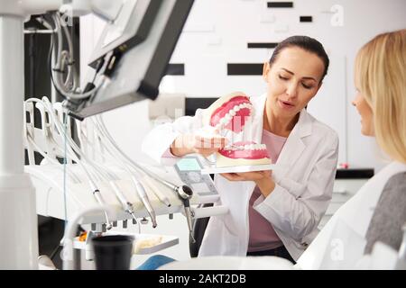 Junge Zahnarzt und Frau in ein Gespräch in der Zahnarzt Klinik Stockfoto