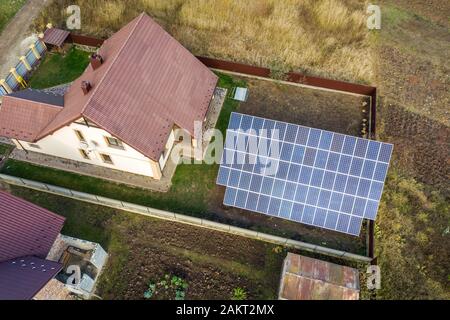 Luftaufnahme von Big Blue solar panel auf dem Boden Struktur in der Nähe von privaten Haus installiert. Stockfoto