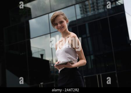 Portrait von Business woman holding einen Tablet-PC. Business Frau auf einem Treffen und wartet Business Partner und mit einem Tablett in den Händen. Stockfoto