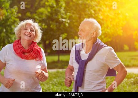Glückliches Paar von Senioren im Park im Sommer läuft Stockfoto