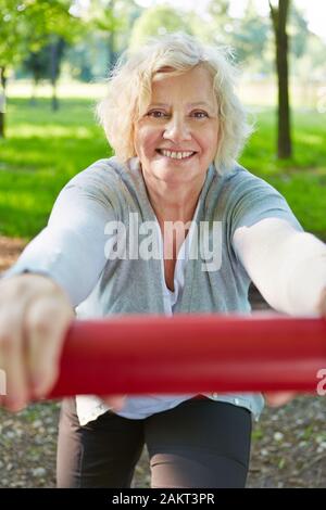 Lächelnd senior Frau Sport in der Natur auf einem Fitness-parcours Stockfoto