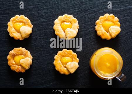 Valentine Holiday Food-Konzept hausgemachtes biologisches, rustikales Zitronenkuchen auf schwarzem Hintergrund Stockfoto