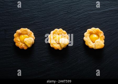 Valentine Holiday Food-Konzept hausgemachtes biologisches, rustikales Zitronenkuchen auf schwarzem Hintergrund Stockfoto