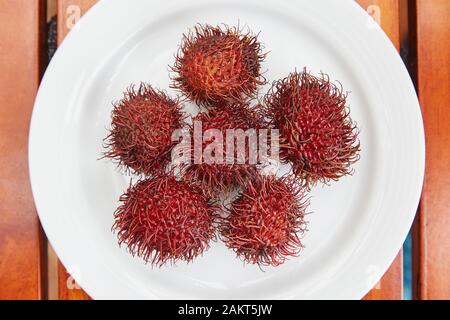 Ein Teller Rambutans, eine stachelige rote Frucht. Stockfoto