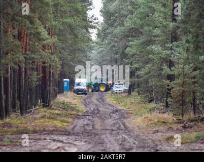 10. Januar 2020, Brandenburg, Grünheide: einen Traktor aus der Landesbetrieb Forst Brandenburg und andere Fahrzeuge werden auf einem Waldweg geparkt auf dem künftigen Standort des Tesla-Gigafactory. In einem großen Wald, östlich der A10 Berliner Ring (Autobahn, die uns elektrische Auto hersteller Tesla plant ein gigafactory zu errichten. In einer ersten Phase ab Sommer 2021, 150 000 Modell 3 und Y Elektroautos sind es jährlich gebaut werden. Foto: Patrick Pleul/dpa-Zentralbild/dpa Stockfoto