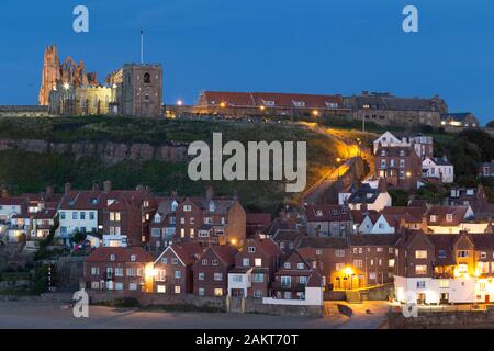 Blick über den Hafen von Whitby auf die Kirche St. Mary und die Ruinen der Abbey in der Dämmerung. Stockfoto