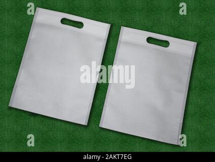 Weißen Stoff Tuch recycelbar ECO Beutel auf grünem Hintergrund. Austausch Plastikbeutel. Speichern der Erde Ökologie. Non Woven Tasche gut für die Umwelt. Stockfoto