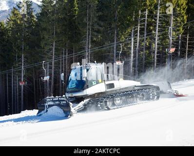 Pistenraupe bewegen auf einer Skipiste Stockfoto