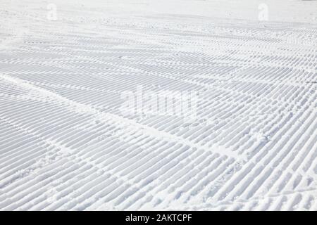 Ski Tracks auf einer frisch präparierten Piste Stockfoto