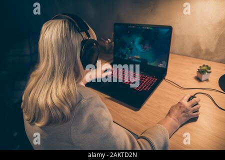 Nahaufnahme hinten hinter dem Blick auf sie schön süchtig konzentrierte grau-haarige blonde Oma Mutter spielt VR-Spiel verbringen freie Zeit bei Stockfoto