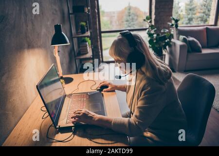 Profil Seitenansicht Portrait von netten attraktiven süchtig fröhlichen Jubel-Grauhaarigen blonden Granny Spielen Web net Virtual VR Spiel auf Industrial Loft Stockfoto