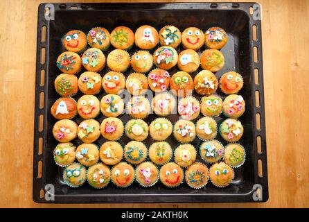 Backblech voller kleiner hausgemachte Muffins mit lustigen Dekoration bereit für Kindergeburtstag Stockfoto