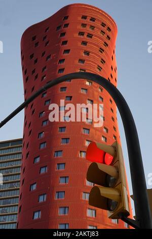 Ungewöhnliches rotes Wolkenkratzer-Stadtgebäude im konzeptionellen Stil dahinter Ampel Stockfoto