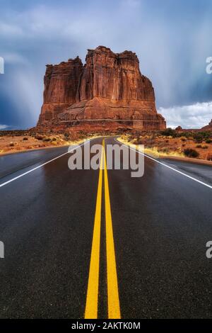 Regenwolken nassen die Straße, die sich durch den Arches National Park in Moab Utah schlängelt Stockfoto