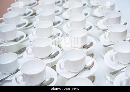 Viele weiße Kaffeetassen. Draufsicht auf viele in Reihen leerer, weißer Tassen gestapelt für Tee oder Kaffee. Stockfoto