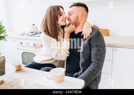 Liebende Paar küsst in der Küche. Paar am Tisch. Stockfoto
