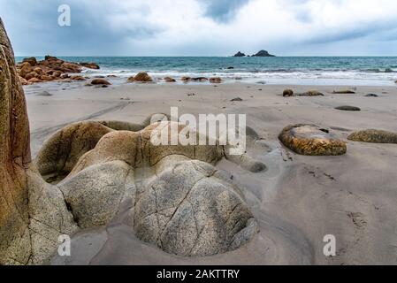 Felsen am Strand in Port Nanven, St Just, Cornwall, UK. Die Brisons Felsen können auf das Meer gesehen werden. Stockfoto