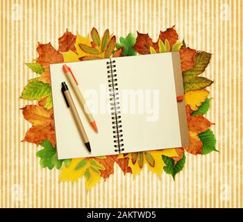 Notebook und Stifte auf trockene Blätter im Herbst Rahmen und gestreiften Hintergrund Stockfoto