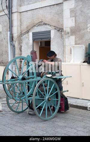 Traditionelle Messerschleifer, die Messer und Klingen auf dem Marktplatz von Nay, Pyrenäen Atlantiques, Nouvelle Aquitanien, Frankreich schärfen Stockfoto