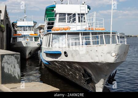 Alte Flussschiffe moorierten am Flussdamm Stockfoto