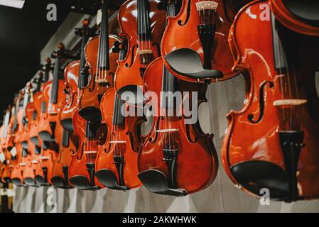 Aussicht auf eine hölzerne braune Geige im Fenster von Ein Musikgeschäft Stockfoto