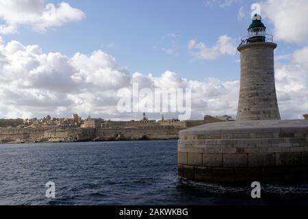 Hafenrundfahrt durch den Grand Harbour - Leuchtturm an der Hafeneinfahrt, im Hintergrund Valletta, Malta Stockfoto
