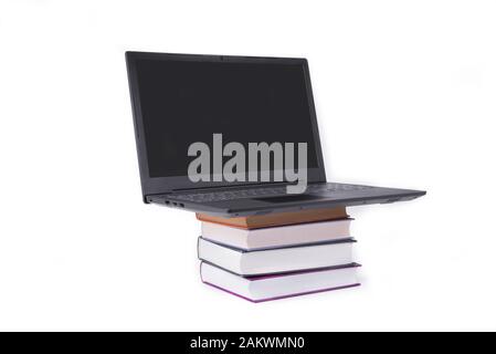 Modernes schlankes Notebook auf einem Stapel Bücher Stockfoto