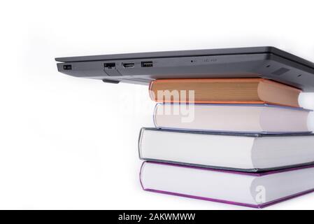 Modernes schlankes Notebook auf einem Stapel Bücher Stockfoto
