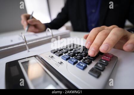 Mittelteil der Geschäftsmann Berechnung der Steuer im Büro Schreibtisch Stockfoto