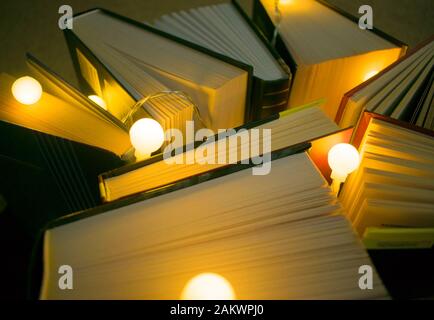 Ein gemütlicher Hintergrund aus Büchern und kleinen Lichtern. Stockfoto