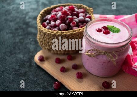 Gefrorener Preiselbeer-Joghurt auf schwarzem Hintergrund. Das Konzept gesunder Desserts. Stockfoto