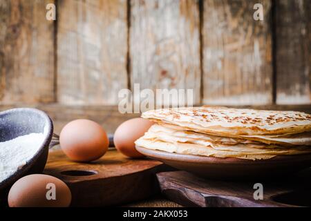 Blasini-Crepes, dünne Pfannkuchen, Zutaten, rustikaler Holztisch Stockfoto