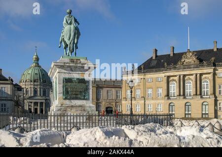 Blauer Himmel und Schnee im Schloss Amalienborg Square Kopenhagen mit Frederiks Kirche, König Frederik's Statue und der Amalienborg Palast an einem sonnigen Wintertag. Stockfoto