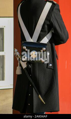 Diensthabende Wache im Königspalast, dem Schloss Amalienborg, in Kopenhagen mit einer schwarz-weißen zeremoniellen Tunika mit schwarzem Sattel und Militärschwert. Stockfoto