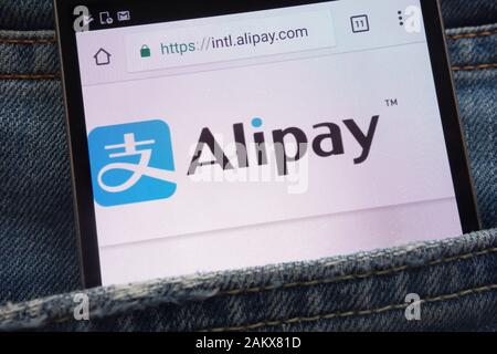 Alipay-Website wird auf dem Smartphone in der Jeans-Tasche versteckt angezeigt Stockfoto