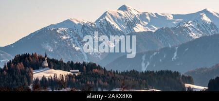 Berglandschaft, malerische Bergkirche am Wintermorgen, großes Panorama Stockfoto