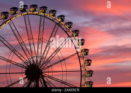 Nahaufnahme der Ferris Radkabinen auf dem Messegelände gegen den dramatischen Sonnenuntergang Stockfoto