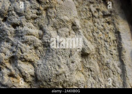 Eine Nahansicht von A bemannt das Gesicht in einem abgenutzten Steinrelief Stockfoto
