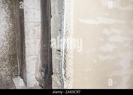 Beschädigte Ecken von verputzten Wänden, sichtbaren Aluminium Ecke. Stockfoto