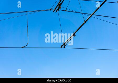 Detailfoto einer Stromversorgung von einer Straßenbahn gegen einen blauen Himmel Stockfoto