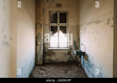 Inneneinrichtung eines alten, zerstörten Badezimmers in einem zerstörten Gebäude Stockfoto