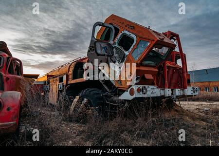 Alter verrostter zerbrochener verlassener sowjetischen Feuerwehrwagen bei Sonnenuntergang am Abend. Stockfoto