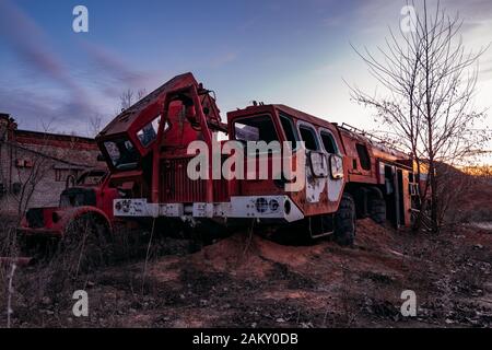Alter verrostter zerbrochener verlassener sowjetischen Feuerwehrwagen bei Sonnenuntergang am Abend. Stockfoto