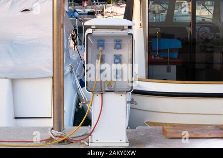 Steckdosen an der Anlegestelle in der Nähe der Küste. Ladestation für Boote in Kroatien. Steckdosen zum Laden von Schiffen im Seehafen. Stockfoto