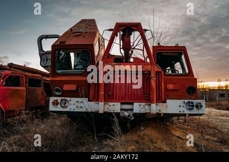 Alter verrostter zerbrochener verlassener sowjetischen Feuerwehrwagen bei Sonnenuntergang am Abend. Stockfoto