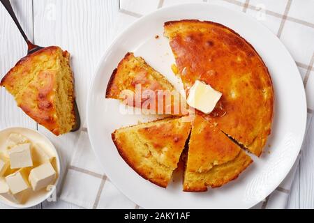 Hausgemachtes Buttermilchkornbrot mit geschmolzener Butter, serviert auf einem Teller, flach, aus nächster Nähe Stockfoto